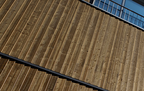 Sägerohe, allseitig mit Lasur behandelte Fassade aus nordischer Fichte.